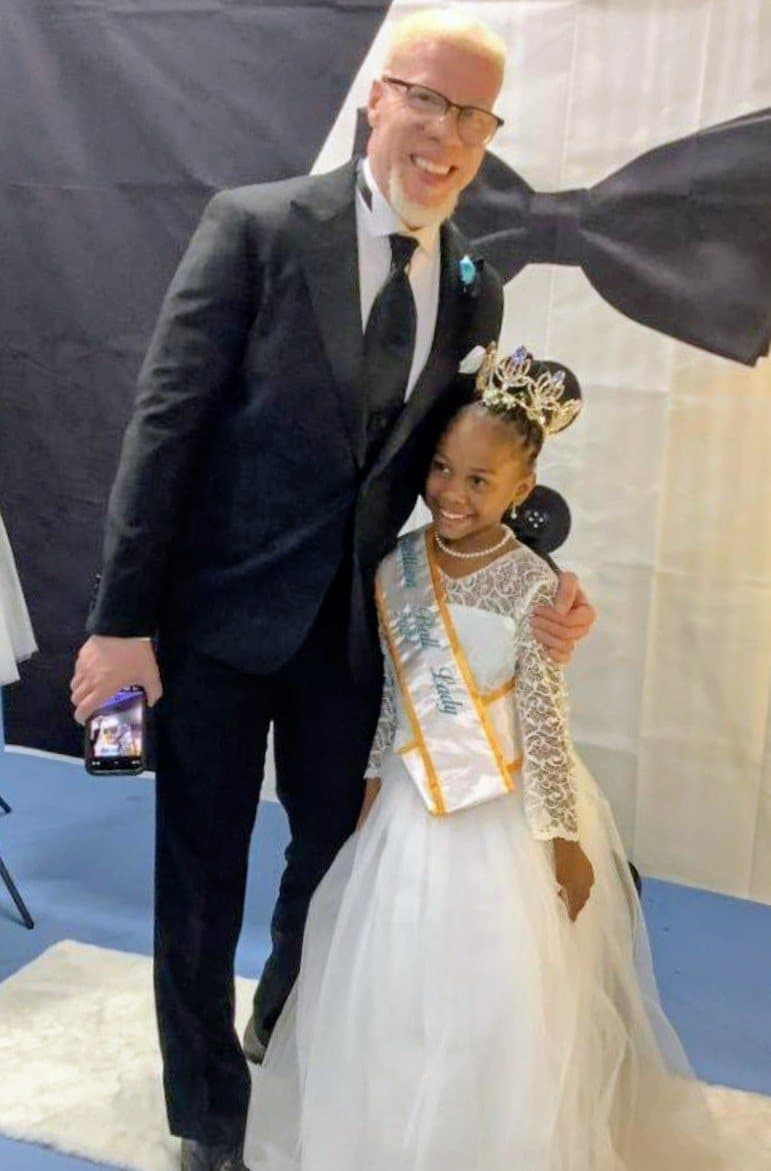 Pastor Keenann Knox with a young lady wearing a crown and sash