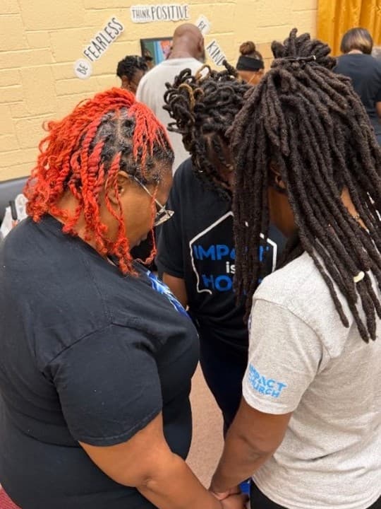Two members holding hands in prayer