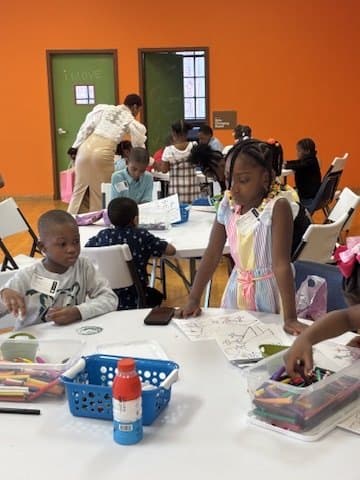 Children working on crafts together at tables in an iKIDZ classroom