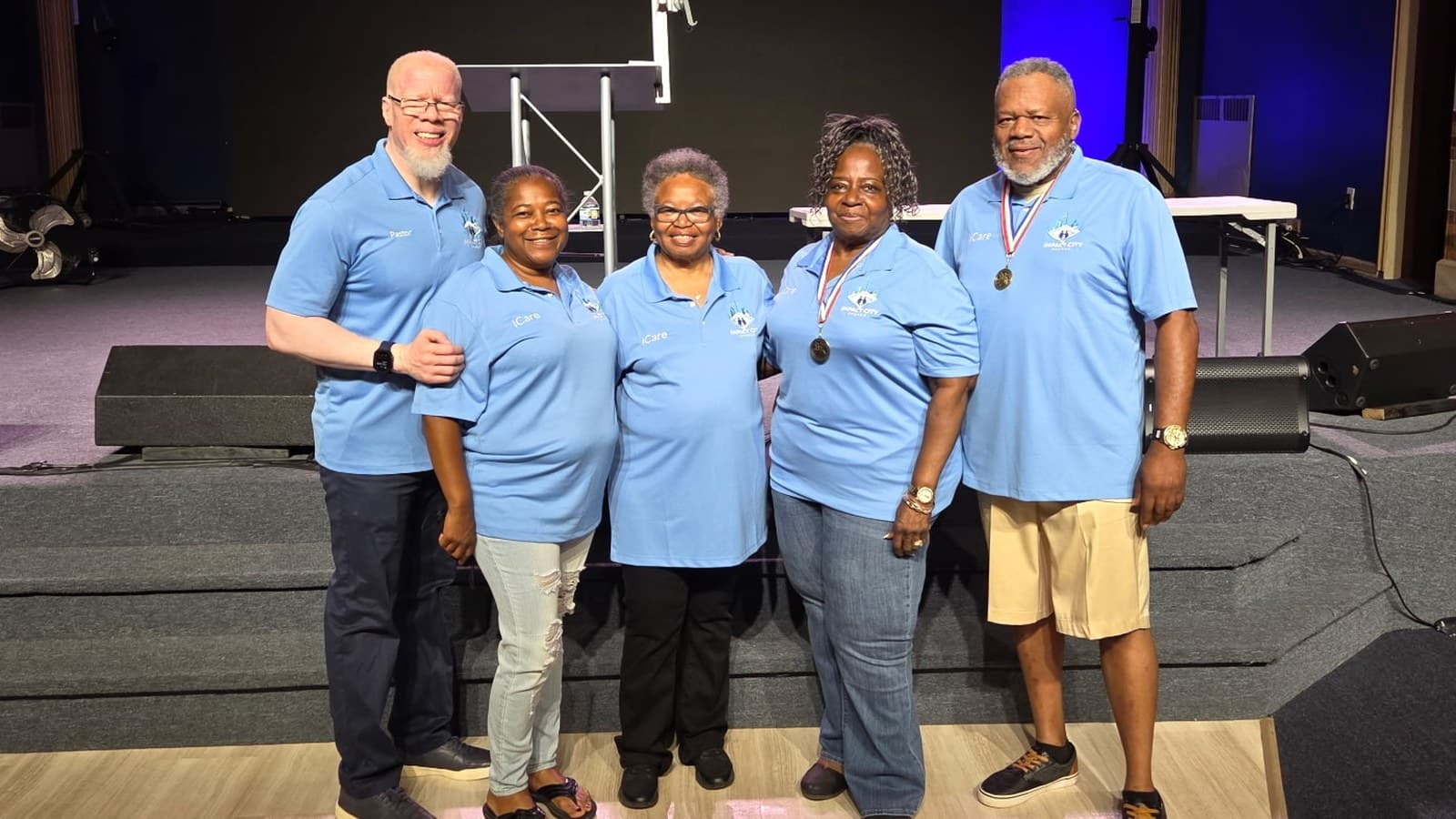 The iCare team in their team shirts on the Impact City stage