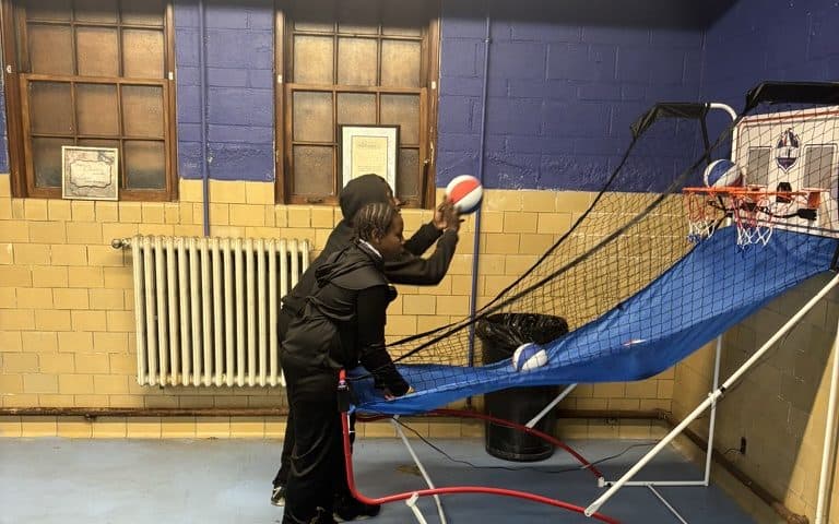 A student on the arcade basketball machine in the game room