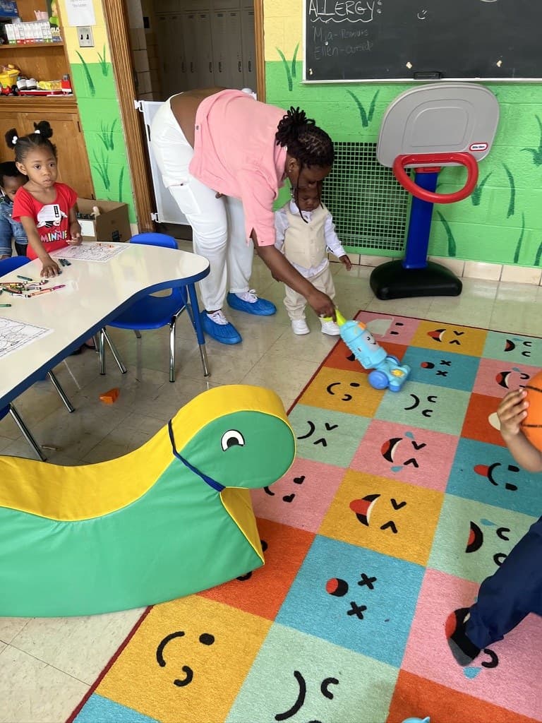 An iKIDZ leader helping a toddler in the preschool room
